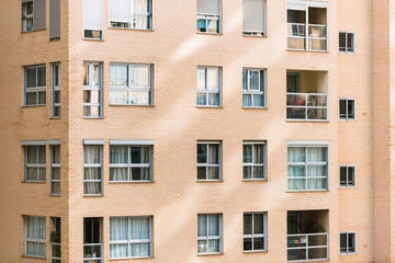 Fototapeta na wymiar Overcrowded brick buildings with clean square windows.