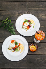 tasty breakfast and two glasses with a cocktail lie on a wooden floor