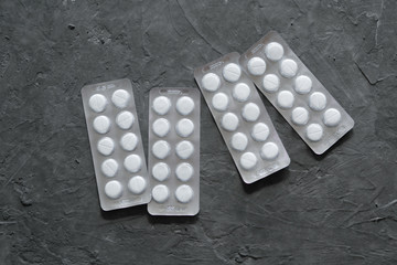 blisters with tablets on a gray background. It can be used in media, web and printed materials on the topic of coronavirus. Copy space.