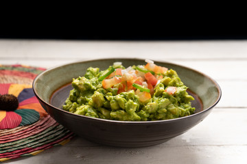 Mexican guacamole with tomato and serrano pepper on white background