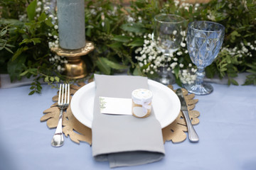 banquet table is decorated with plates, cutlery, glasses, candles and flower arrangements