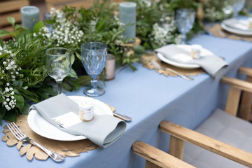 banquet table is decorated with plates, cutlery, glasses, candles and flower arrangements