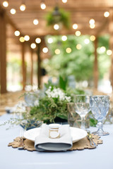 banquet table is decorated with plates, cutlery, glasses, candles and flower arrangements