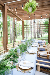 banquet table is decorated with plates, cutlery, glasses, candles and flower arrangements