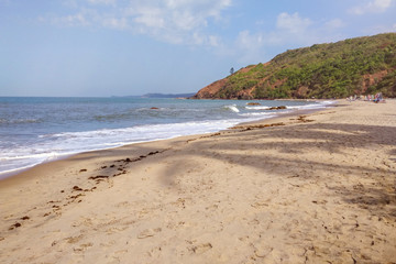 Fototapeta na wymiar Beautiful deserted sandy beach by the sea, the shadows of palm trees on the sand.