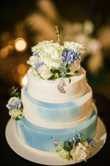 wedding cake stands on a served table and is decorated with flowers