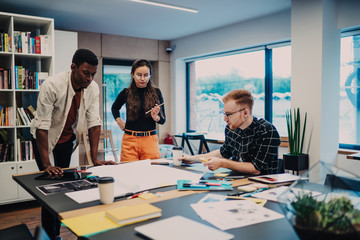 Young colleagues looking at drawing in office
