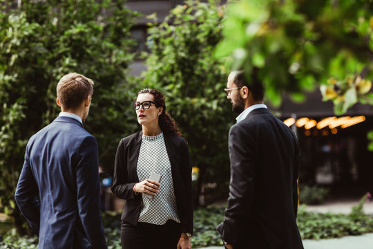 Female and male entrepreneurs discussing business strategy while standing outdoors