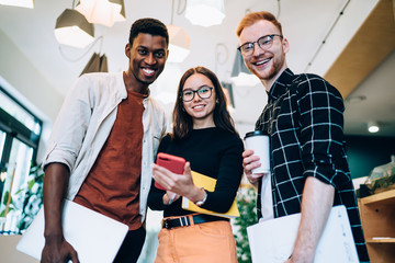 Cheerful diverse colleagues looking at camera