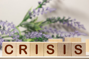 Businessman removes wooden blocks with the word Crisis. The exit from the crisis and financial stability. Focus on resolving the midlife crisis. The rise of the economy and business development.