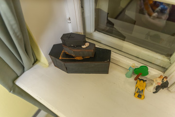 toy coffins on the white surface of the windowsill