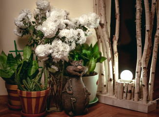 cat and green plant figurine in home interior decoration