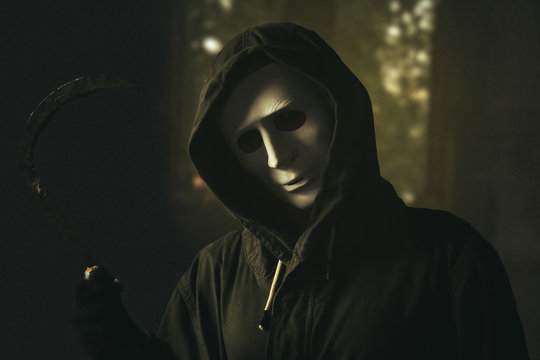 Maniac in white mask and hoodie showing fist