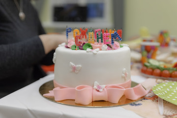 Birthday cake without burning candles on a plate on pink background