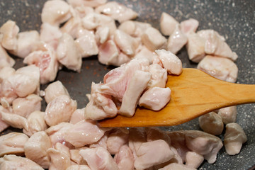 Pieces of chicken fillet fried in a pan. Cooking process close up.
