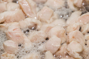 Pieces of chicken fillet fried in a pan. Cooking process close up.