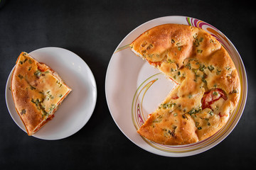 A piece of cake with chicken, herbs and tomatoes on a plate. Homemade delicious food for diet.