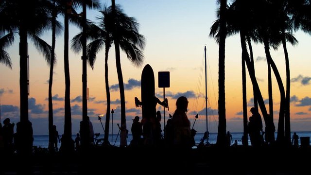 Tourists walking at sunset in Waikiki beach Hawaii in 4k
