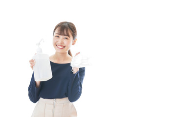 Obraz premium マスクをアルコール消毒する若い女性