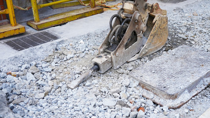 road repair equipment. hydraulic jackhammer in a road construction. Excavator with a bucket is building a new road. construction industry