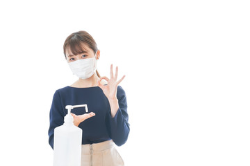 OKサインをしながらアルコール消毒をする若い女性