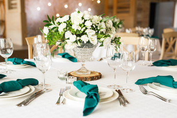 banquet table is decorated with plates, cutlery, glasses, candles and flower arrangements