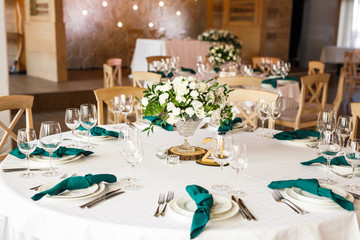 banquet table is decorated with plates, cutlery, glasses, candles and flower arrangements
