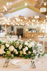 banquet table is decorated with plates, cutlery, glasses, candles and flower arrangements