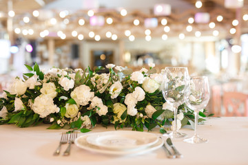 banquet table is decorated with plates, cutlery, glasses, candles and flower arrangements