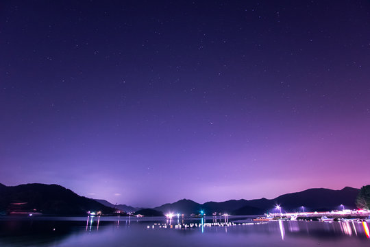 River By Mountains Against Star Field At Night