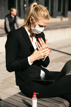 Businesswoman working with laptop waring face mask and hand sanitizer
