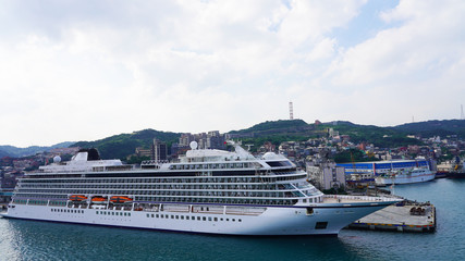 White large beautiful cruise ship moored in an Asian port. luxury liner in the passenger port for boarding passengers. travels in the pacific ocean