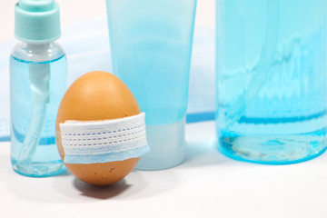 Fototapeta na wymiar Funny Easter eggs with masks, Coronavirus prevention medical surgical masks and hand sanitizer gel for hand hygiene corona virus protection.