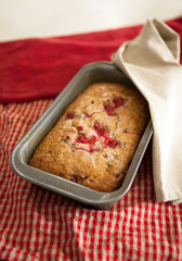sweet raspberry bread freshly baked in a loaf pan with dish towels