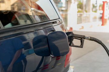 Fill up petrol tank gasoline fuel petrol in car being filled with fuel at gas petrol station.