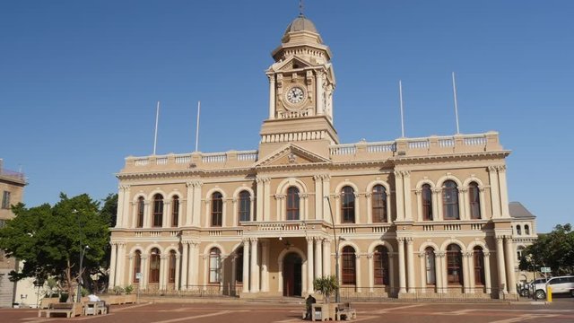 Move forward across Market Square toward Port Elizabeth City Hall. Tilt up to see Clocktower and push in with camera