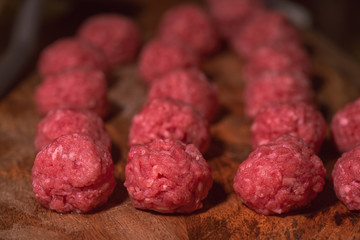 Raw meatballs on the wooden board