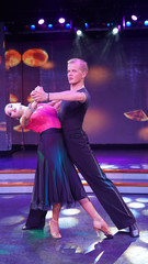 a pair of dancers dancing on stage in the light of colorful bright spotlights and smoke. support in...