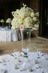 elegant white flowers and candles arranged on table for wedding event