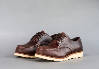 Men fashion brown shoe leather over gray background.