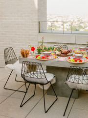A beautifully decorated table set up on a rooftop for an outdoor dinner
