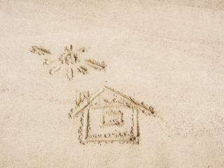 Sun and house on yellow sand drawn by finger, close up view. Texture of yellow sand. Egyptian beach in february. Selective soft focus. Blurred background