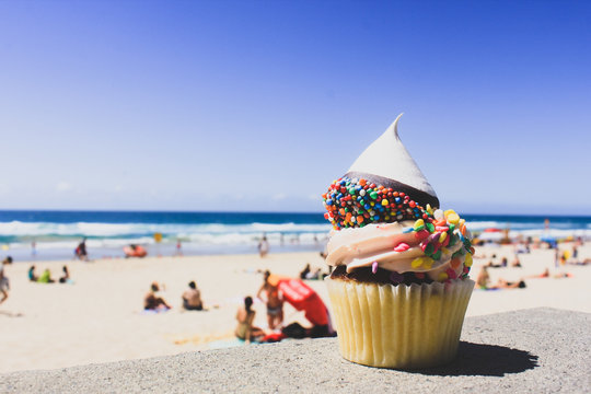 Close-up Of Cupcake On Beach Against Clear Blue Sky