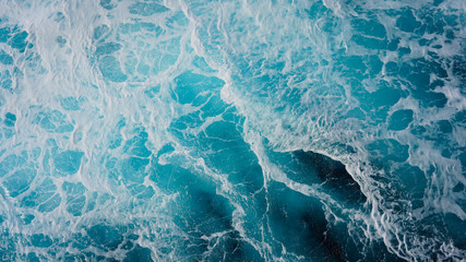 Abstraction of sea foam in the ocean. Dark water stormy waves turquoise pacific ocean water on a sunny day