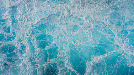 Abstraction of sea foam in the ocean. Dark water stormy waves turquoise pacific ocean water on a sunny day