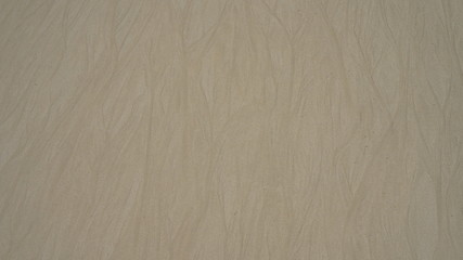 Yellow sand texture. golden sand to the beach. fine white sand. smooth lines of water on clean ocean sand