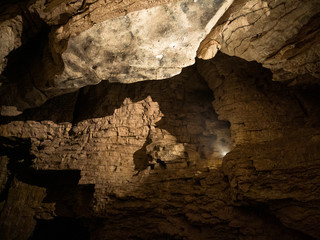 Fototapeta na wymiar Dimmed light coming through in dark cave. Shot in New Zealand