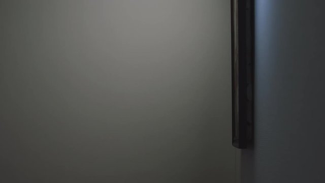 Thief shines a flashlight on the picture on the wall and then steals it