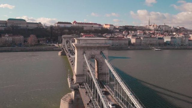 aerial rotating drone shot around the Chain Bridge in Budapest with the Castle and Mathias Church in the background on a sunny day