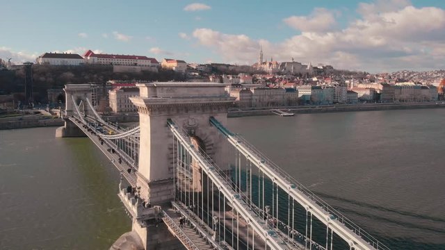 aerial flying forward drone shot towards the Chain Bridge in Budapest with the Castle and Mathias Church in the background on a sunny day